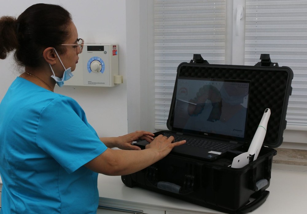 Mitarbeiterin bedient den Intraoralscanner am Laptop